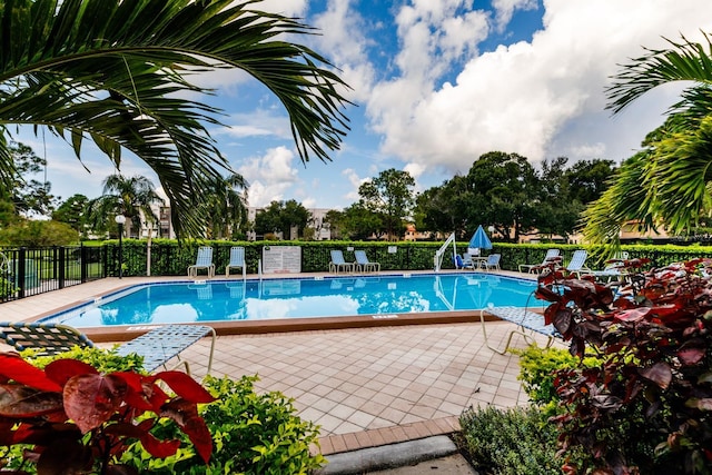 community pool featuring fence and a patio