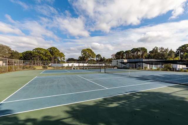 view of tennis court featuring fence and community basketball court