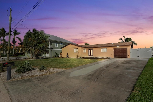 5108 Commonwealth Rd, Palmetto, FL 34221 - single story home featuring stucco siding, a gate, an attached garage, a lawn, and concrete driveway