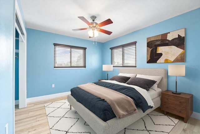 5108 Commonwealth Rd, Palmetto, FL 34221 - bedroom with multiple windows, baseboards, wood finished floors, and a ceiling fan
