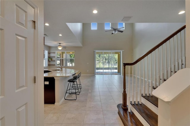 foyer featuring ceiling fan, light tile patterned flooring, stairway, recessed lighting, and baseboards