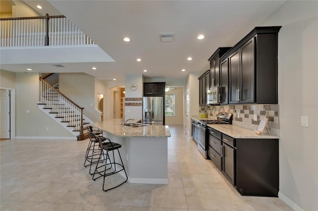 kitchen featuring stainless steel appliances, a kitchen bar, recessed lighting, tasteful backsplash, and baseboards