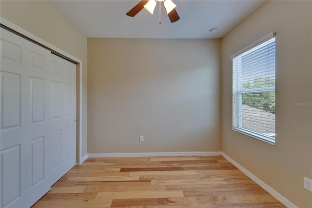 unfurnished bedroom with light wood-type flooring, baseboards, and a closet