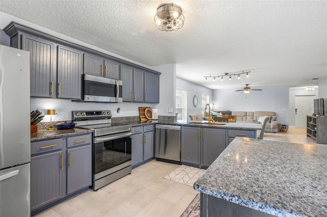 13643 Tramore Dr, Odessa, FL 33556 - kitchen with appliances with stainless steel finishes, open floor plan, a sink, a textured ceiling, and ceiling fan