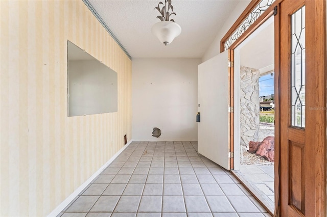 5 Marina Ter, Treasure Island, FL 33706 - foyer featuring light tile patterned floors, a textured ceiling, wallpapered walls, and baseboards