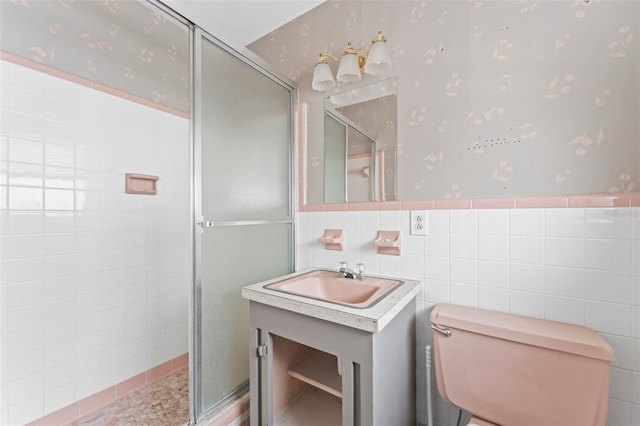 5 Marina Ter, Treasure Island, FL 33706 - bathroom featuring wallpapered walls, a shower stall, toilet, vanity, and tile walls