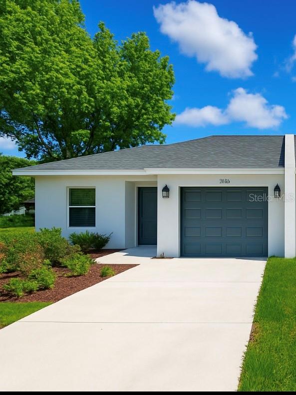 1253 Dosseywood Ln, Lakeland, FL 33811 - view of front of house with concrete driveway, an attached garage, and stucco siding