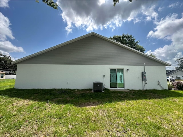 1253 Dosseywood Ln, Lakeland, FL 33811 - rear view of property featuring stucco siding, a yard, and central AC