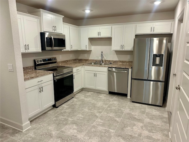 1253 Dosseywood Ln, Lakeland, FL 33811 - kitchen featuring appliances with stainless steel finishes, a sink, white cabinets, stone countertops, and recessed lighting