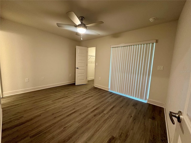 1253 Dosseywood Ln, Lakeland, FL 33811 - unfurnished bedroom featuring baseboards, dark wood-style floors, a spacious closet, a ceiling fan, and a closet