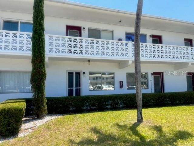 8455 112th St Unit 212, Seminole, FL 33772 - back of house featuring a yard, a balcony, and stucco siding