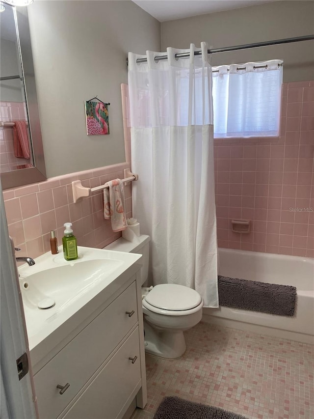 8455 112th St Unit 212, Seminole, FL 33772 - bathroom with toilet, tile walls, shower / bathtub combination with curtain, vanity, and wainscoting
