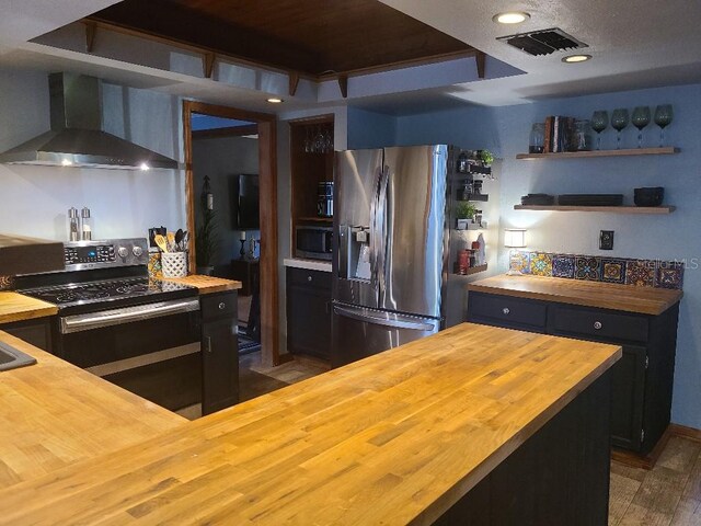 314 Bloomingfield Dr, Brandon, FL 33511 - kitchen featuring wood counters, wall chimney range hood, stainless steel appliances, wood finished floors, and recessed lighting