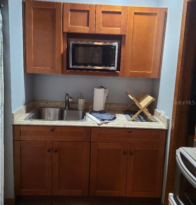 314 Bloomingfield Dr, Brandon, FL 33511 - kitchen featuring stainless steel microwave, a sink, stove, and light stone counters