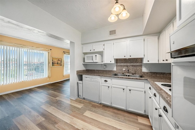 2002 Australia Way E Unit 66, Clearwater, FL 33763 - kitchen with a sink, white appliances, white cabinetry, tasteful backsplash, and a textured ceiling