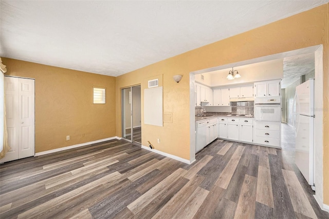 2002 Australia Way E Unit 66, Clearwater, FL 33763 - kitchen with white appliances, dark wood-style floors, white cabinetry, a sink, and baseboards