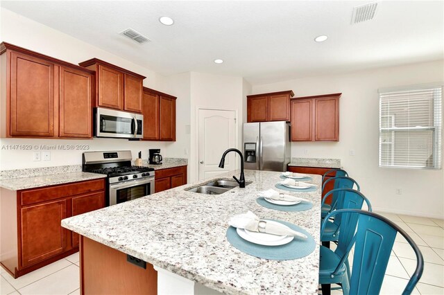 5247 Wildwood Way, Davenport, FL 33837 - kitchen with stainless steel appliances, a sink, light tile patterned flooring, a center island with sink, and recessed lighting