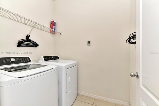 5247 Wildwood Way, Davenport, FL 33837 - laundry area with washing machine and clothes dryer, light tile patterned flooring, and baseboards