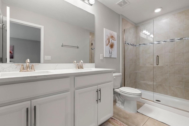 5270 Neil Dr, Saint Petersburg, FL 33714 - bathroom featuring toilet, a stall shower, tile patterned flooring, double vanity, and recessed lighting
