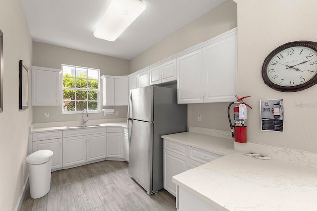 5270 Neil Dr, Saint Petersburg, FL 33714 - kitchen featuring freestanding refrigerator, a sink, white cabinets, and light countertops