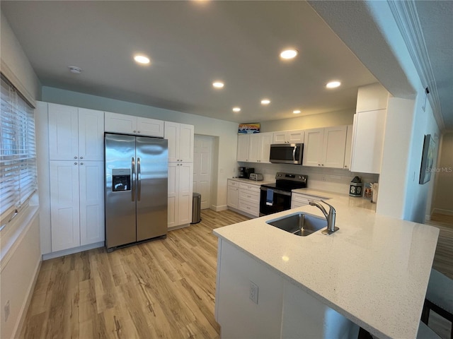 474 20th Ave, Indian Rocks Beach, FL 33785 - kitchen featuring stainless steel appliances, a sink, a peninsula, light wood-type flooring, and recessed lighting