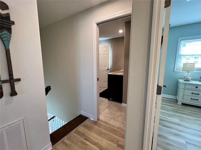 474 20th Ave, Indian Rocks Beach, FL 33785 - corridor with an upstairs landing, light wood-style flooring, and baseboards