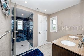 474 20th Ave, Indian Rocks Beach, FL 33785 - bathroom with healthy amount of natural light, a stall shower, tile patterned flooring, double vanity, and recessed lighting