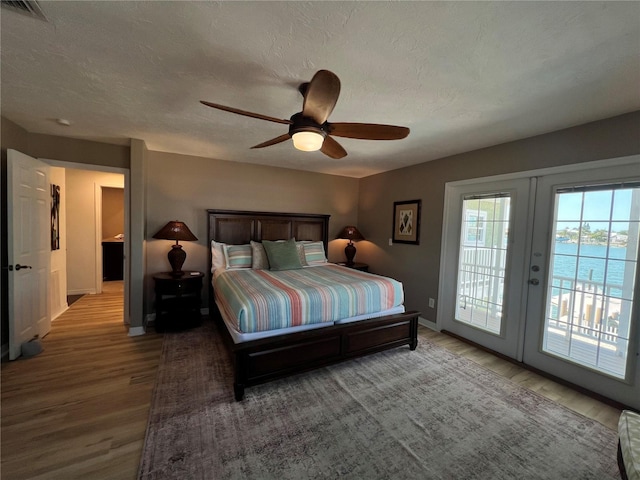 474 20th Ave, Indian Rocks Beach, FL 33785 - bedroom with wood finished floors, access to exterior, french doors, baseboards, and a textured ceiling
