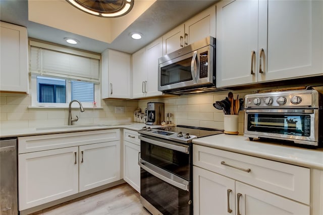 9484 Tara Cay Ct Unit 8, Seminole, FL 33776 - kitchen with appliances with stainless steel finishes, a sink, backsplash, light countertops, and recessed lighting