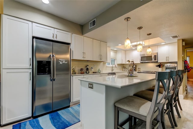 9484 Tara Cay Ct Unit 8, Seminole, FL 33776 - kitchen with stainless steel appliances, white cabinets, tasteful backsplash, recessed lighting, and a breakfast bar