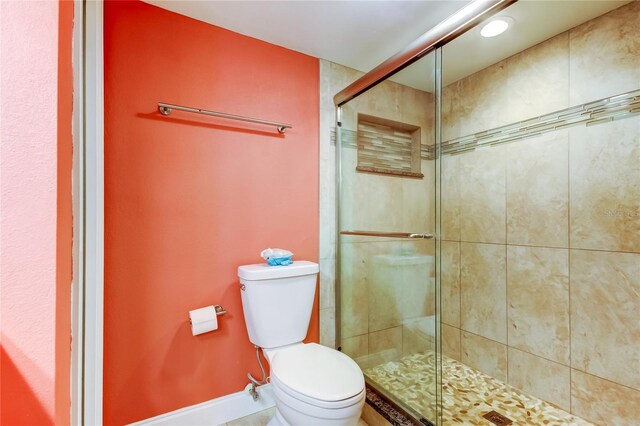 9484 Tara Cay Ct Unit 8, Seminole, FL 33776 - bathroom with toilet, a stall shower, and baseboards