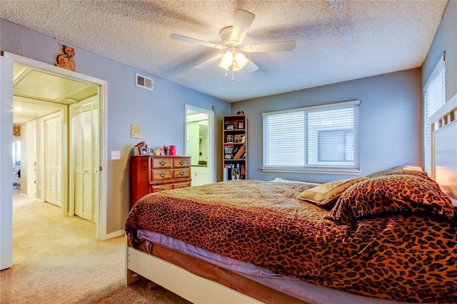 9484 Tara Cay Ct Unit 8, Seminole, FL 33776 - bedroom with light carpet, a textured ceiling, ceiling fan, and connected bathroom