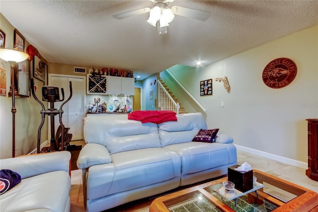9484 Tara Cay Ct Unit 8, Seminole, FL 33776 - living room with stairway, a textured ceiling, a ceiling fan, and baseboards