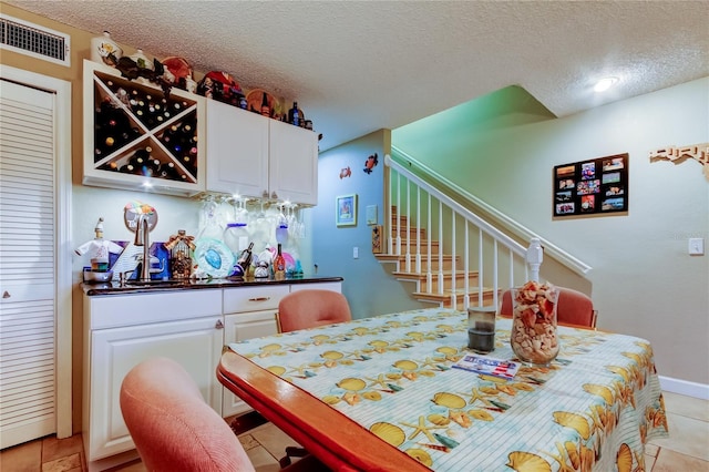 9484 Tara Cay Ct Unit 8, Seminole, FL 33776 - dining room with stairs, a textured ceiling, and light tile patterned floors
