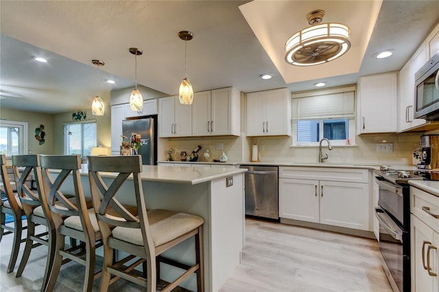 9484 Tara Cay Ct Unit 8, Seminole, FL 33776 - kitchen with stainless steel appliances, a breakfast bar, decorative backsplash, white cabinetry, and recessed lighting