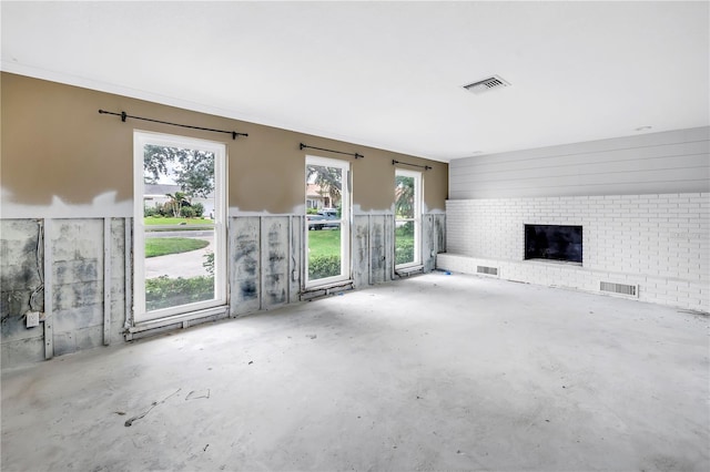 5215 Denver St NE, Saint Petersburg, FL 33703 - unfurnished living room featuring unfinished concrete floors and a brick fireplace