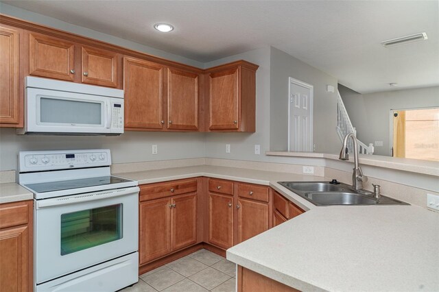6954 Hawthorne Trace Ln, Riverview, FL 33578 - kitchen featuring white appliances, a sink, light tile patterned floors, light countertops, and brown cabinetry