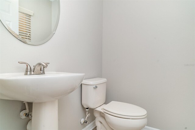 6954 Hawthorne Trace Ln, Riverview, FL 33578 - half bathroom featuring baseboards, toilet, and a sink