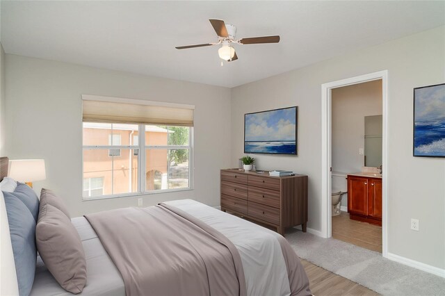 6954 Hawthorne Trace Ln, Riverview, FL 33578 - bedroom with baseboards, a ceiling fan, ensuite bath, and light carpet