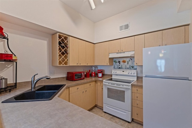200 4th Ave S Unit 220, Saint Petersburg, FL 33701 - kitchen featuring white appliances, light brown cabinetry, under cabinet range hood, and light countertops