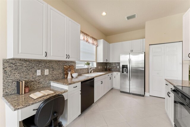 5009 Sandy Brook Cir, Wimauma, FL 33598 - kitchen with stainless steel fridge, black dishwasher, decorative backsplash, white cabinetry, and light stone counters