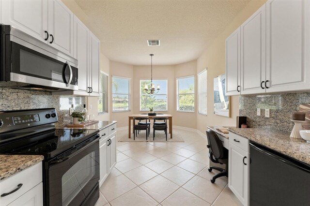 5009 Sandy Brook Cir, Wimauma, FL 33598 - kitchen with stainless steel microwave, black electric range, white cabinetry, and backsplash