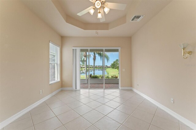 5009 Sandy Brook Cir, Wimauma, FL 33598 - unfurnished room featuring light tile patterned floors, a ceiling fan, a tray ceiling, and a water view