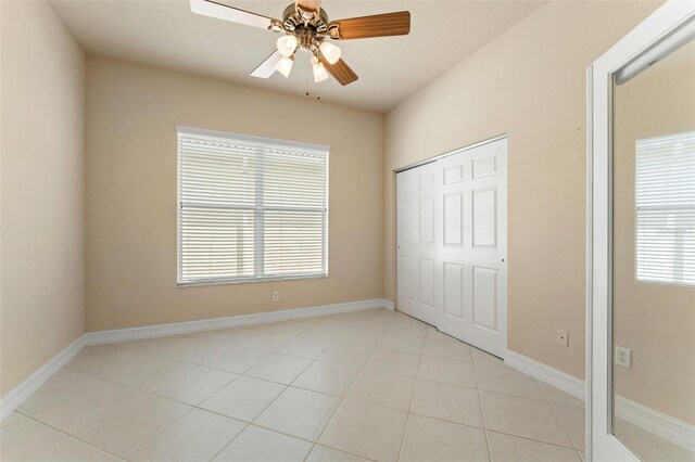 5009 Sandy Brook Cir, Wimauma, FL 33598 - unfurnished bedroom with light tile patterned floors, a ceiling fan, and a closet