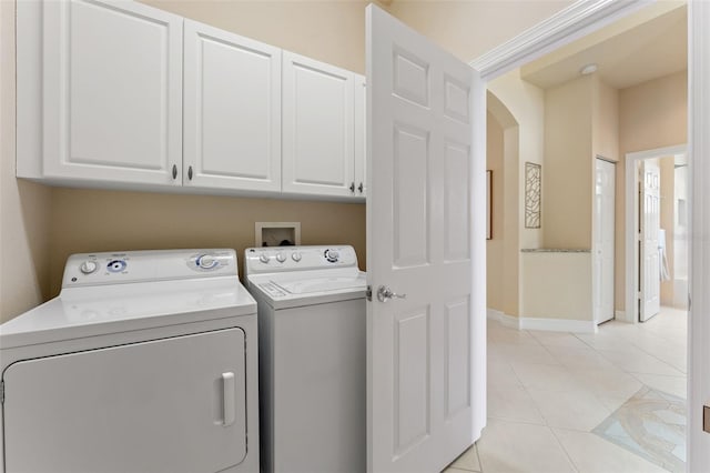 5009 Sandy Brook Cir, Wimauma, FL 33598 - laundry room featuring washing machine and dryer, cabinet space, light tile patterned floors, and arched walkways