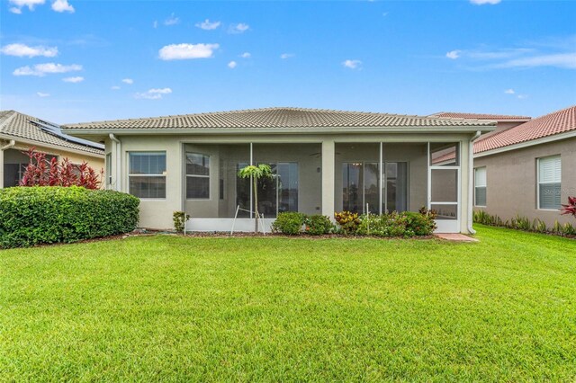 5009 Sandy Brook Cir, Wimauma, FL 33598 - rear view of property with a tiled roof, a sunroom, a yard, and stucco siding
