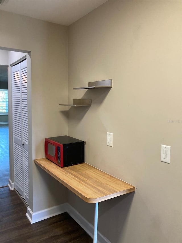 office space featuring baseboards and dark wood-type flooring
