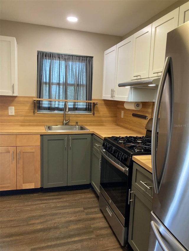 kitchen featuring stainless steel appliances, a sink, recessed lighting, dark wood-style flooring, and butcher block countertops