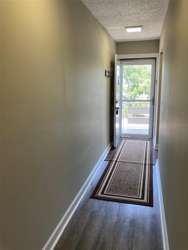 entryway featuring a textured ceiling and baseboards