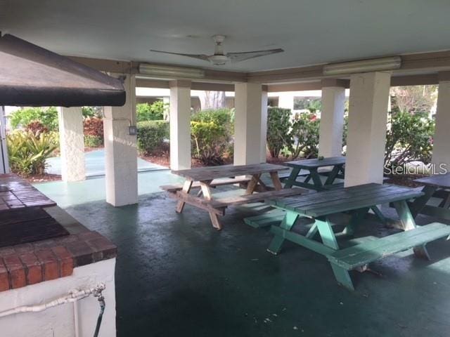 view of patio with outdoor dining area and a ceiling fan